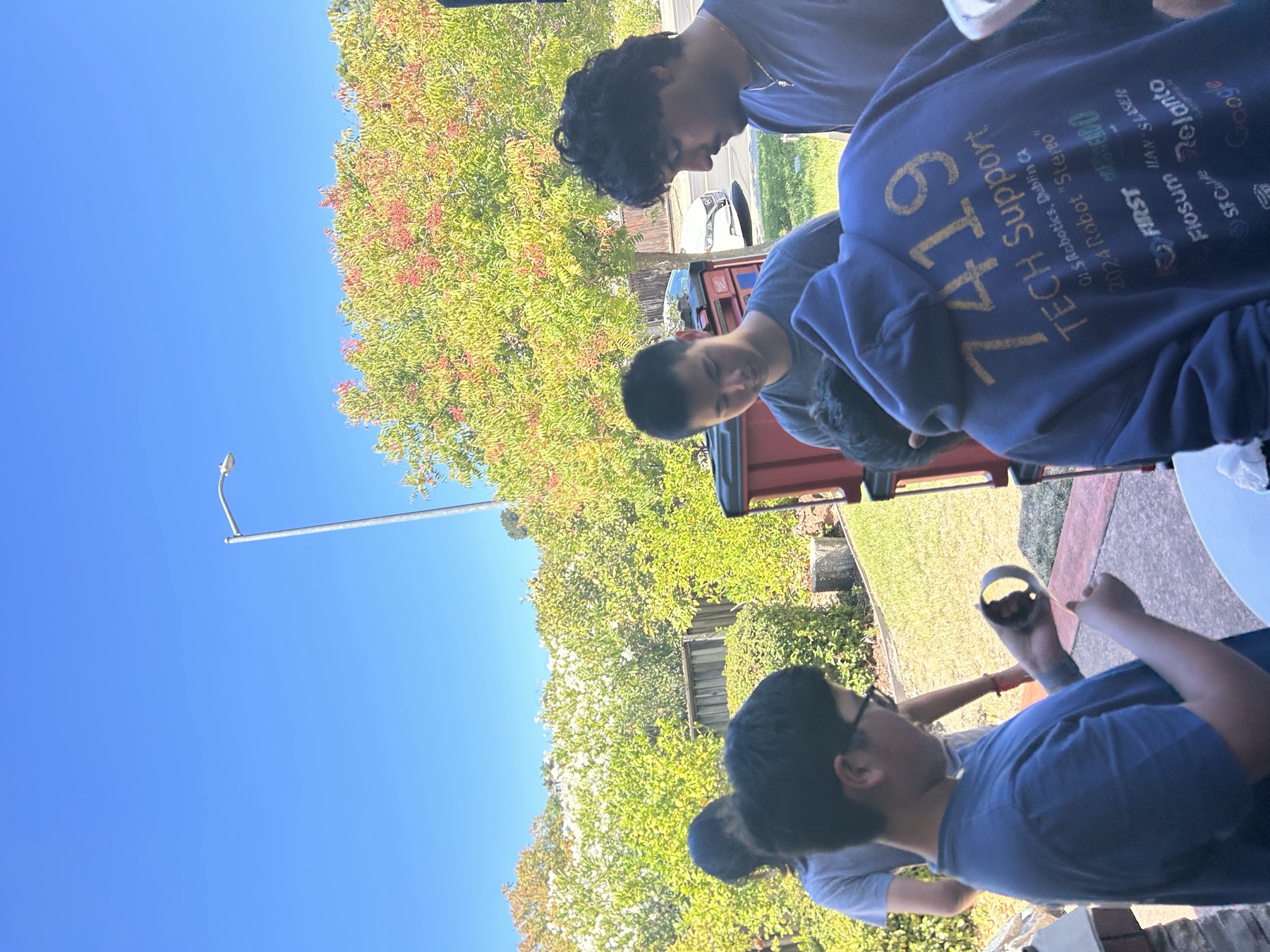 Team members gathered around an outdoor work table