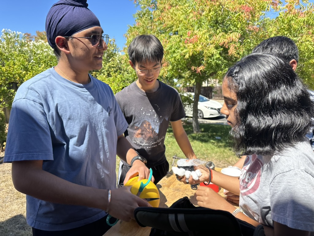 Team members working on a project at an outdoor table