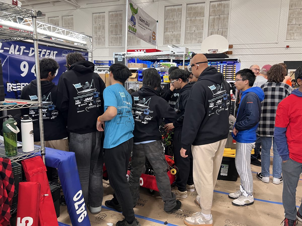 Students working on the robot in the pit