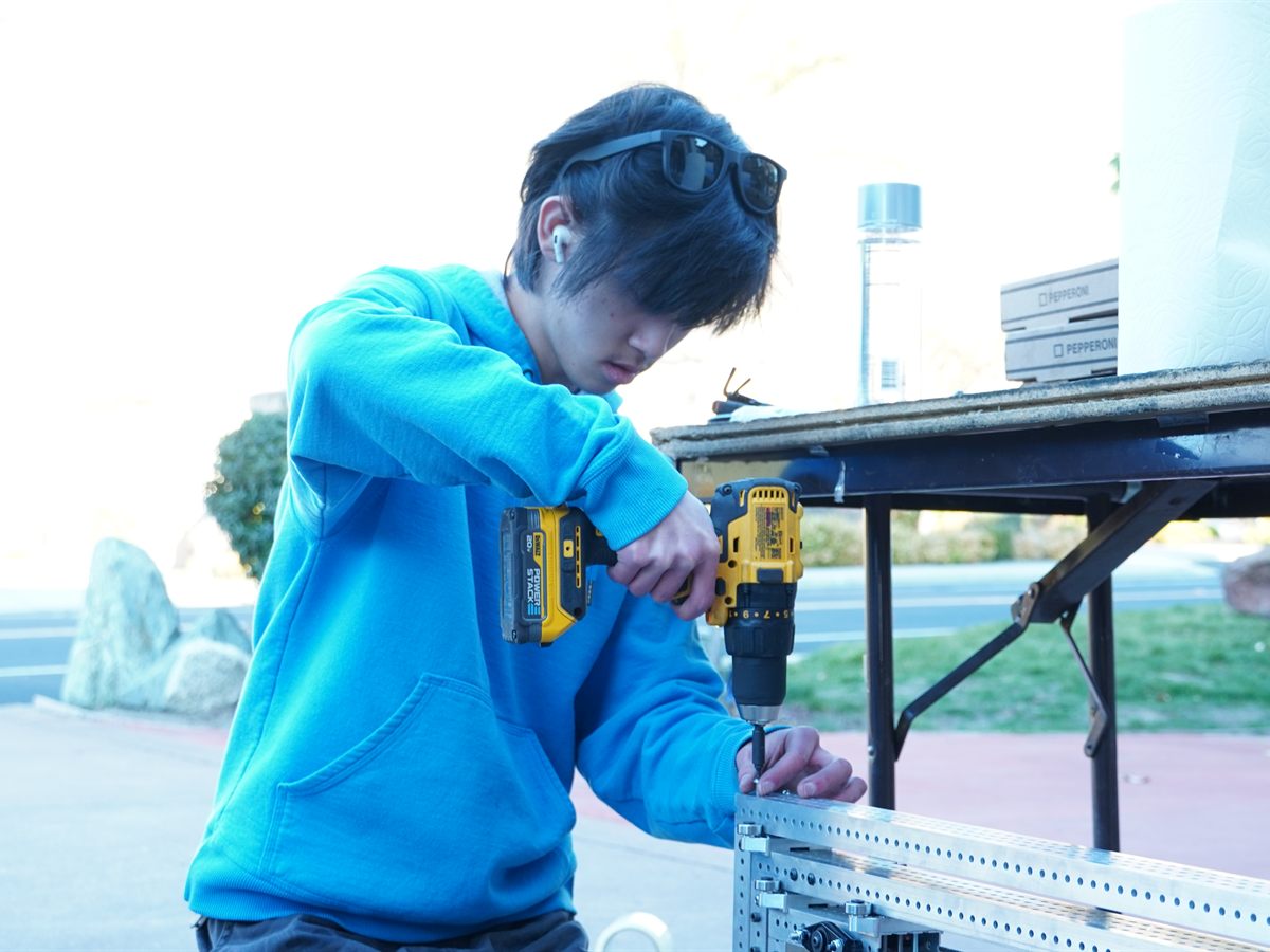 A student fabricating a robot part with shop tooling