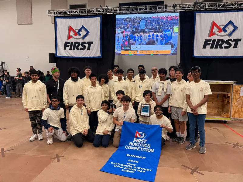 Team members holding the blue FIRST winner banner